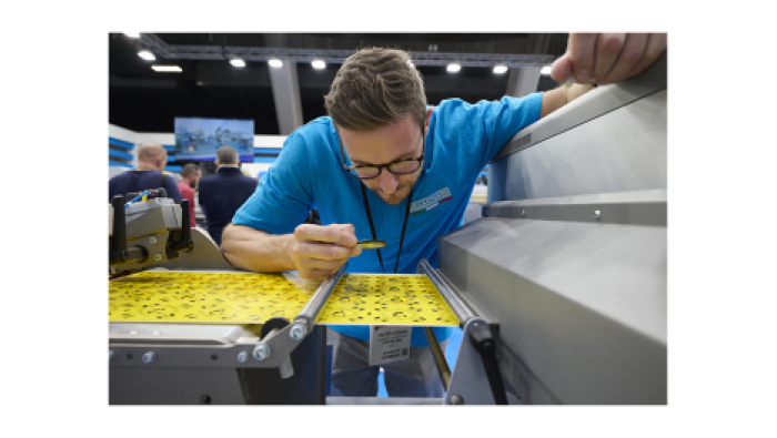 A technician inspect a labels using a loupe at Labelexpo Europe 2023.