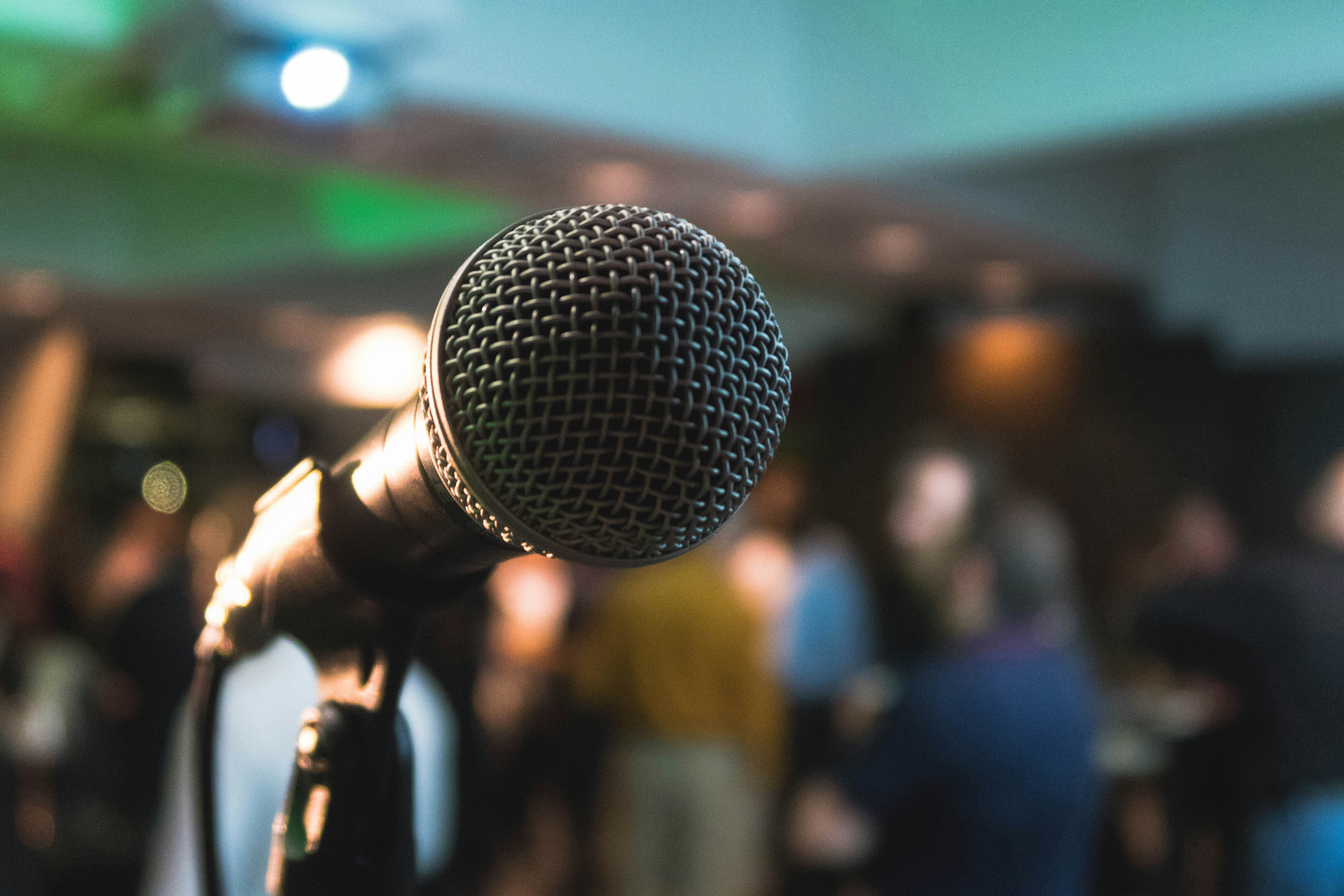 A microphone against a blurred background of a crowd. 
