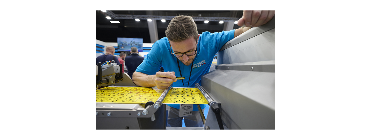 A technician inspect a labels using a loupe at Labelexpo Europe 2023.