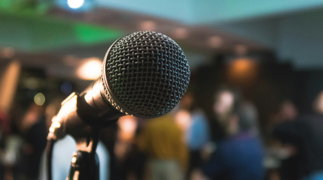 A microphone against a blurred background of a crowd. 